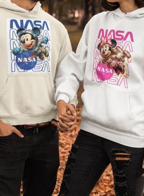 Two people wearing NASA-themed hoodies with cartoon characters in an outdoor setting.