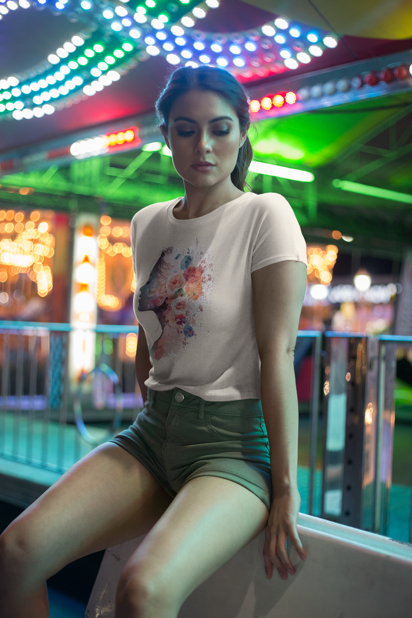 Woman sitting on a bench at an amusement park with colorful lights in the background