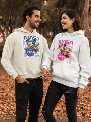 Two people wearing NASA-themed hoodies with cartoon characters in an outdoor setting.