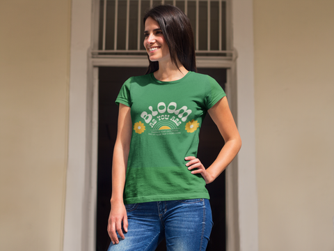 Woman wearing a green t-shirt with 'Bloom as You Are' text and sunflower graphics.